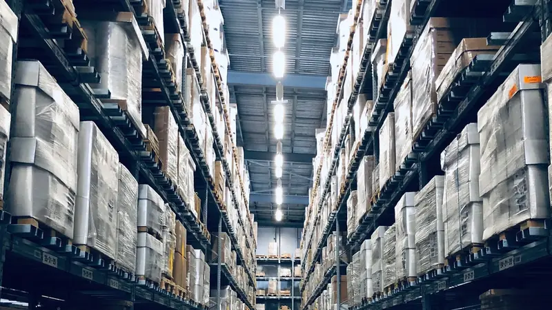 Warehouse aisle of neatly organised, catalogued packages on tall shelves