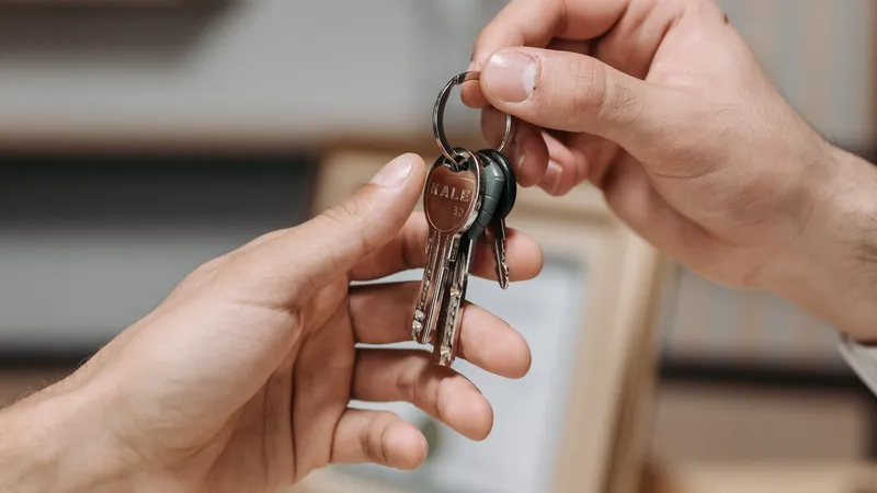 Close-up of a set of keys being handed from one person to another